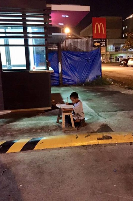 Menino de 9 anos que vive nas ruas usa luz de lanchonete para estudar e comove na web